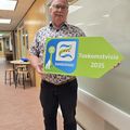 Wim van der Toorn staat met bordje in hand met erop  Toekomstvisie 2035 en het logo erbij