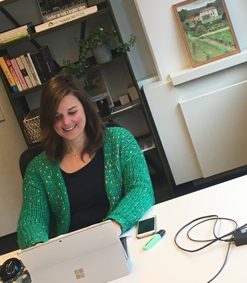 Vrouw werkend aan bureau op een flexplek
