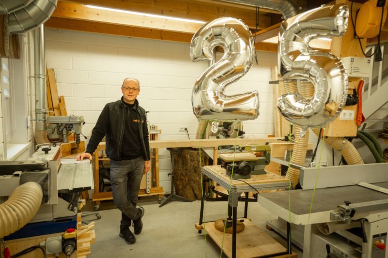 Ceel van Heijkop in zijn werkplaats. Er staan ook ballonnen die het getal 25 vormen. 