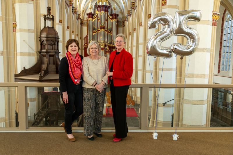 3 vrijwilliger van de Mattheus Passion in de Sint Maartenskerk. Linksboven zijn de zilveren ballonnen zichtbaar in de vorm van het getal 25