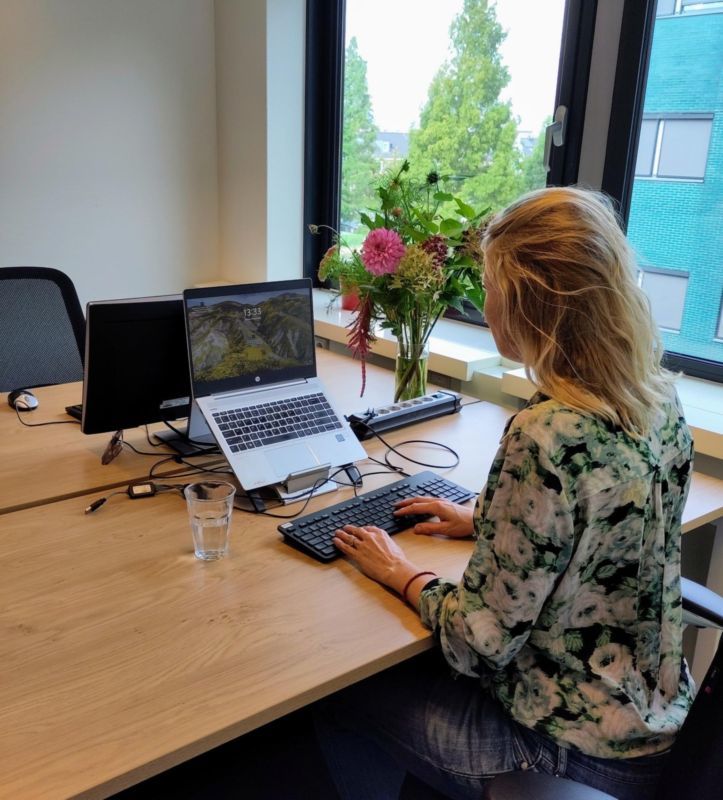 Vrouw zit achter laptop in het Groene Huis