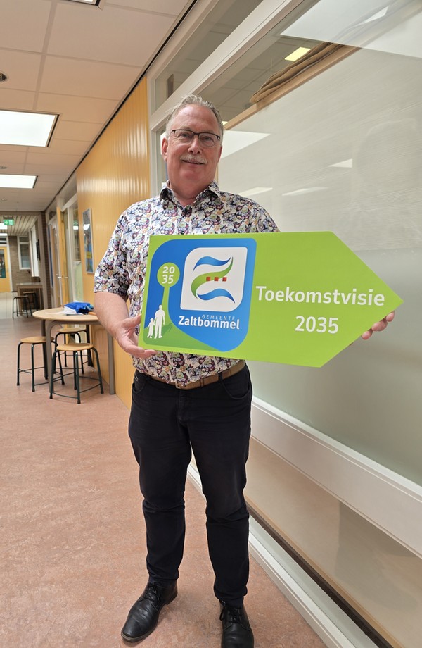 Wim van der Toorn staat met bordje in hand met erop  Toekomstvisie 2035 en het logo erbij